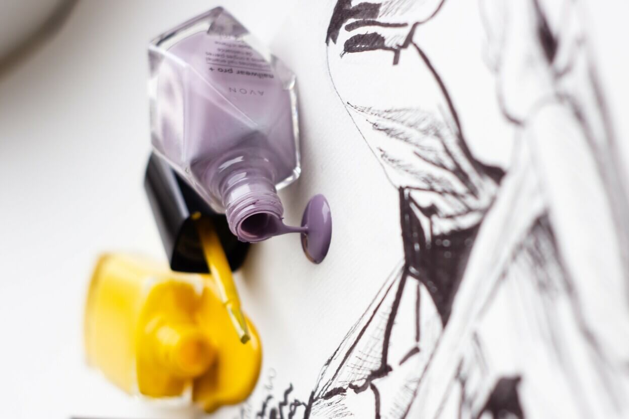 Una imagen de botellas de pintura de uñas en diferentes colores. 