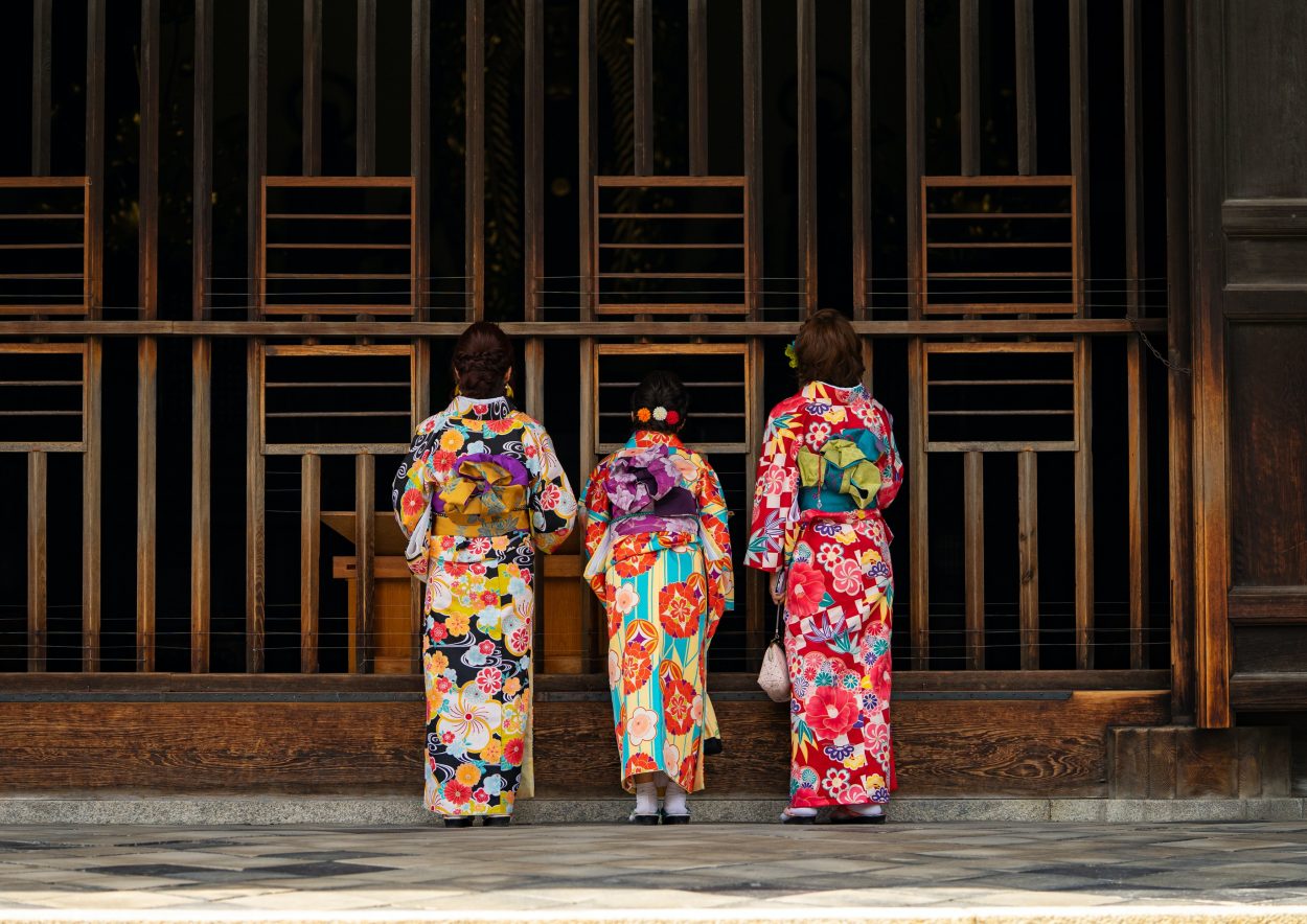 Tres mujeres de pie con la espalda vistiendo Wafuku/Kimono