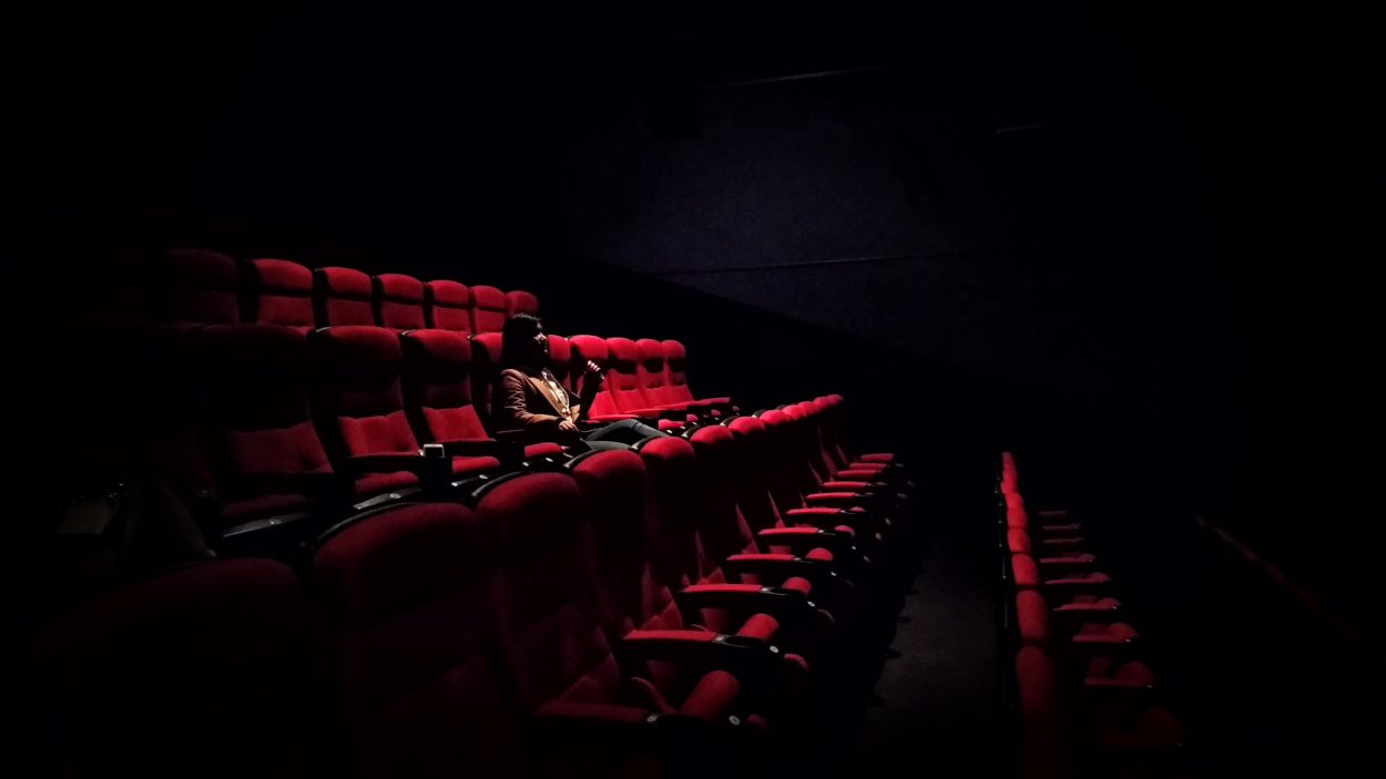 La diferencia entre IMAX y un teatro normal: todas las diferencias Una persona está sentada sola en un teatro.