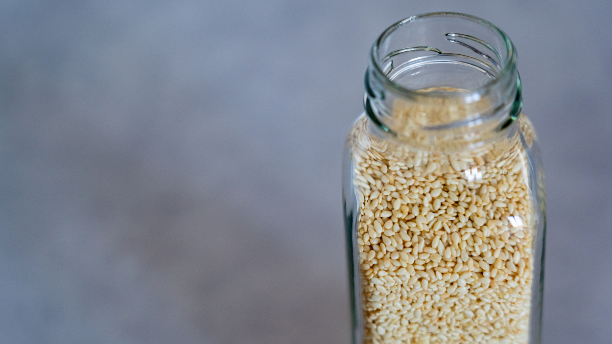Un frasco lleno de semillas de sésamo blanco