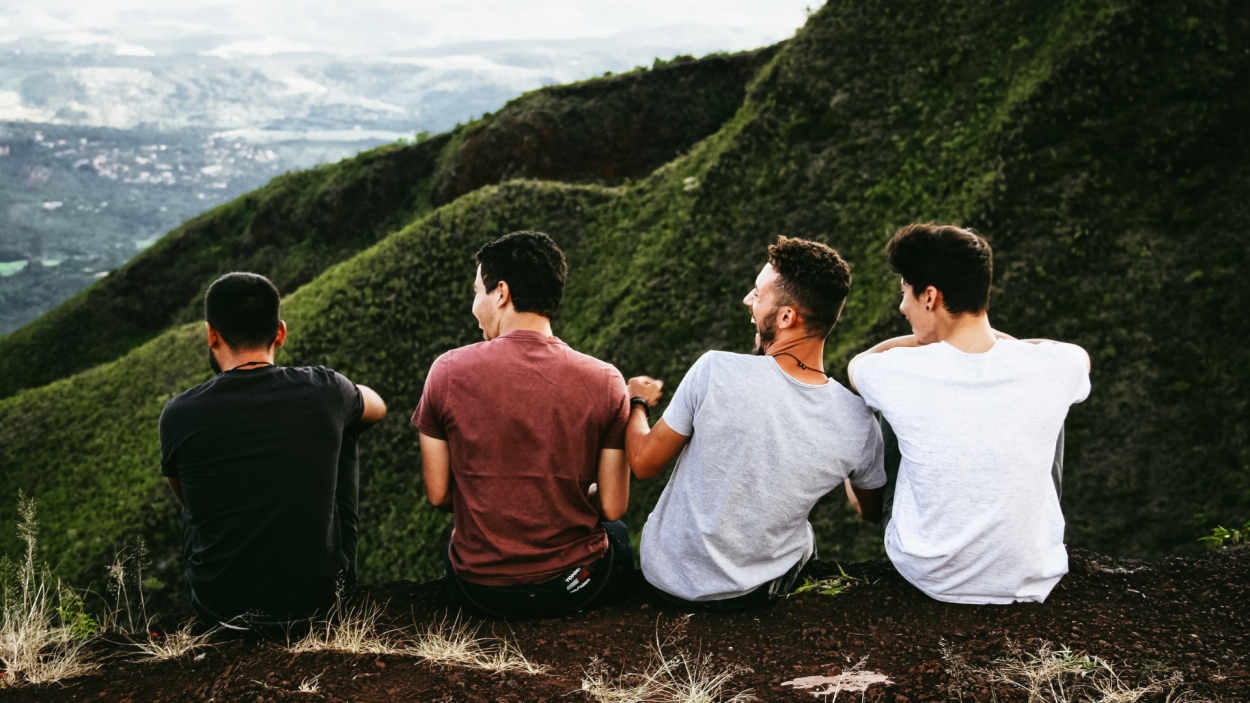 Un grupo de hombres sentados en la ladera de una montaña.