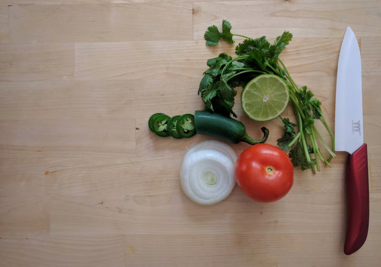 Un cuchillo junto a un par de verduras.