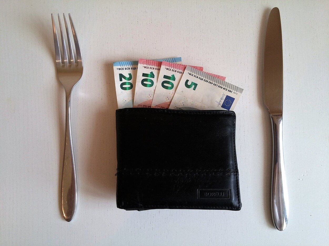 Una imagen de tenedores y cuchillos junto con billetes y propinas.